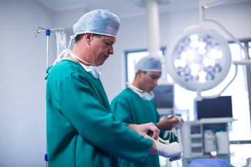 Obraz premium Surgeon wearing surgical gloves in operation theater