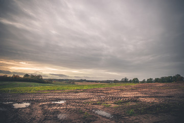 Landschap met wielsporen op een modderig veld