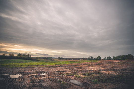 Fototapeta Landscape with wheel tracks on a muddy field
