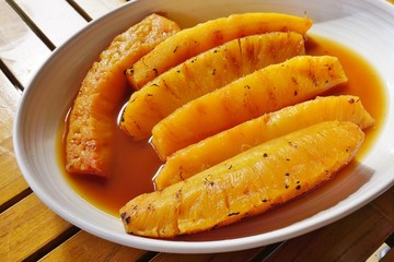 Slices of roasted caramelized pineapple in caramel sauce