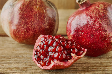 Ripe pomegranate fruit on wooden background.