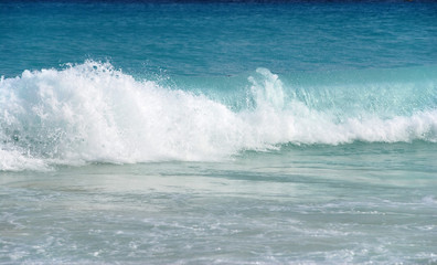 blue ocean wave splashing on shore