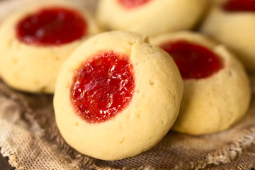 Engelsaugen Weihnachtsplätzchen gefüllt mit Erdbeermarmelade, fotografiert mit natürlichem Licht (Selektiver Fokus, Fokus diagonal durch die Mitte des ersten Plätzchens)