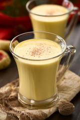 Eggnog oder Eierpunsch, ein Amerikanisches Weihnachtsgetränk, fotografiert mit natürlichem Licht (Selektiver Fokus, Fokus ein Drittel in das erste Getränk)