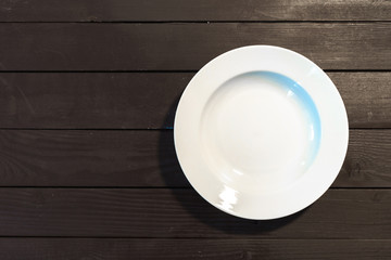 Empty white plate on wooden table