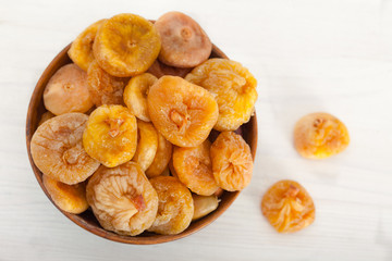 Healthy dried figs in wooden bowl, top view