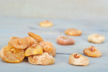 Pile of healthy, delicious dry figs on blue table