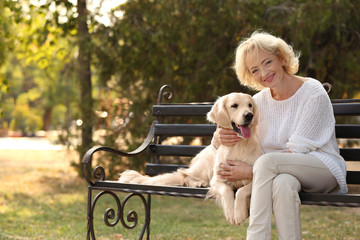 Senior woman sitting on bench with dog