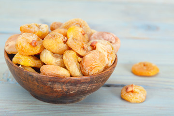 Fototapeta premium Delicious dried figs in wooden bowl over blue background
