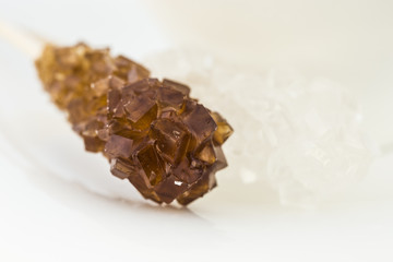 Sticks to crystallize brown and white sugar on a white backgroun