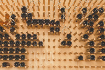 The bottles on the shelves of the wine cellar. Front view.