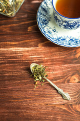 cup of tea on wooden background and tea leaves