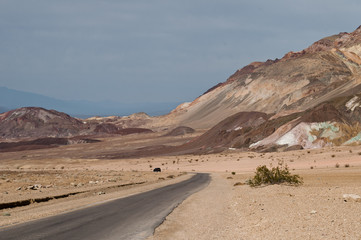 Desert landscape, narrow road and geologic formation called Artist's Palette in the scenic Artist Drive, the Death Valley National Park, CA