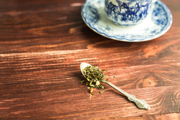 cup of tea on wooden background and tea leaves