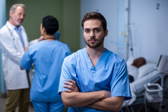 Portrait of male nurse standing in ward