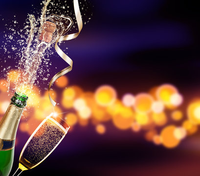 Bottle of champagne with glass over blur background