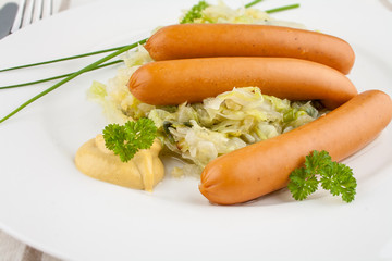 Three mini wieners on fried cabbage with mustard
