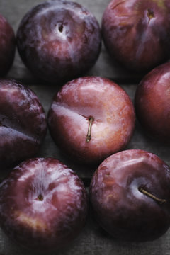 Overhead view of plums on wooden table