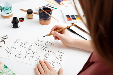 Girl writing calligraphy on postcards. Art design. - obrazy, fototapety, plakaty