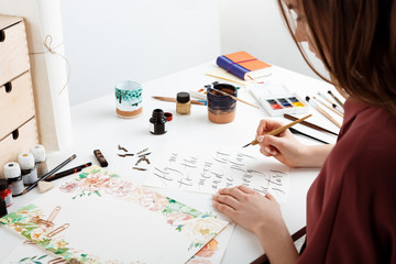 Girl writing calligraphy on postcards. Art design.