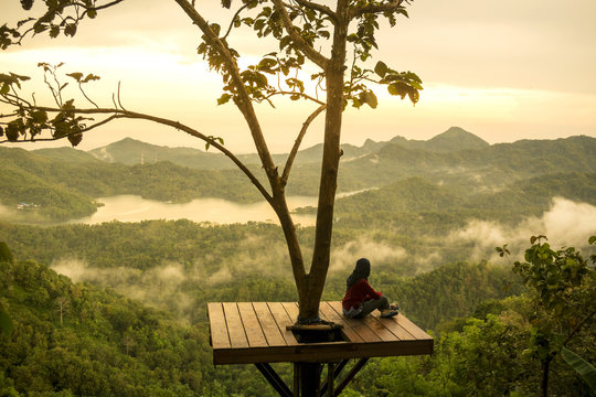 Woman sitting on observation point and looking at view