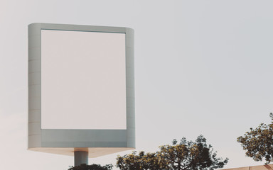 Mock up of blank white vertical advertising billboard, clear white sky behind and plants below
