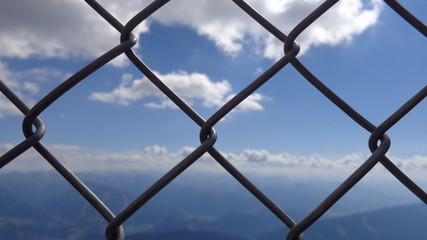 Sky through a metal mesh fence