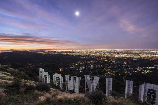 High angle view of Hollywood sign by illuminated city at dusk