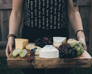 Midsection of woman carrying breakfast on wooden board