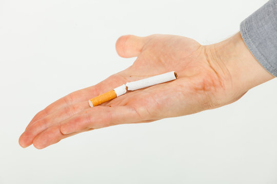 Closeup of broken cigarette on male hand.