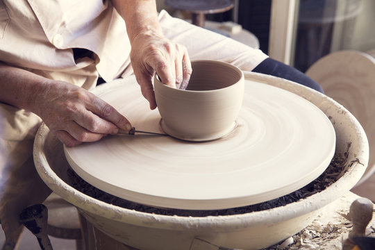 Woman molding clay on pottery wheel
