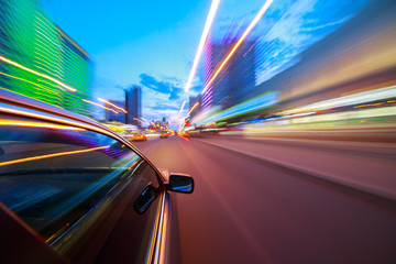 The car moves at fast speed at the night. Blured road with lights with car on high speed.