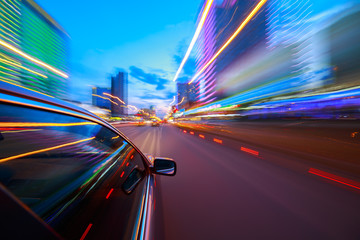 The car moves at fast speed at the night. Blured road with lights with car on high speed.