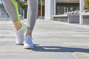 Woman with white sport shoes ready to run outdoor in the city