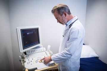 Fototapeta na wymiar Doctor using patient monitoring machine in ward