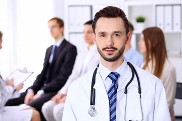 Fototapeta premium Friendly bearded male doctor with patients