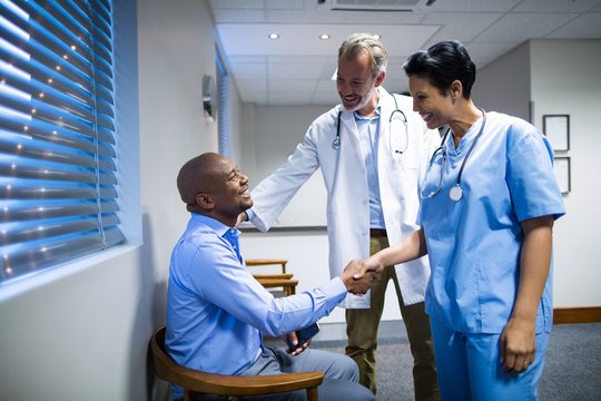 Doctors shaking hands with patient