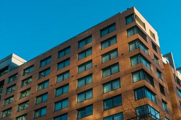 orange office building with light reflections and blue windows
