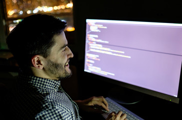 Software developer computer at dark home office