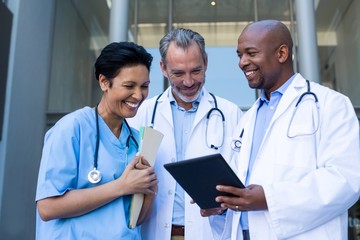 Surgeons and nurse having discussion on digital tablet
