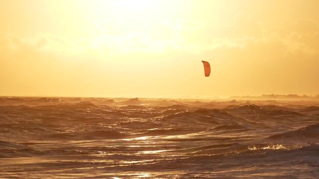 une voile de kitesurf sur la mer au coucher de soleil