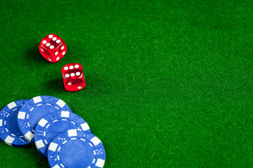poker chips and dice on green background top view