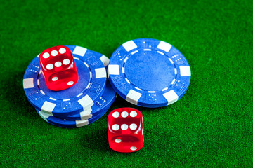 poker chips and dice on green background top view