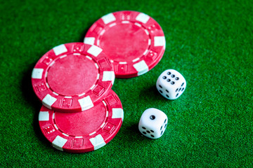 poker chips and dice on green background top view