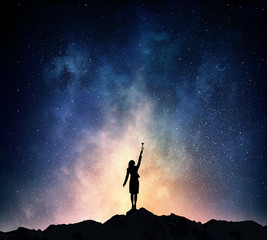 Fototapeta premium Businesswoman against starry sky . Mixed media