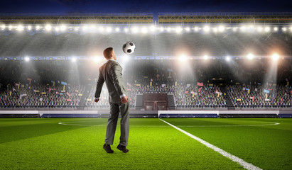 Businessman playing soccer . Mixed media