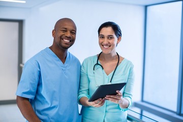 Portrait of doctor using digital tablet in corridor