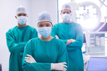 Fototapeta na wymiar Team of surgeons wearing surgical mask in operation theater