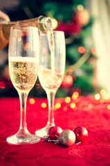 Two glasses of champagne near beautiful christmas tree