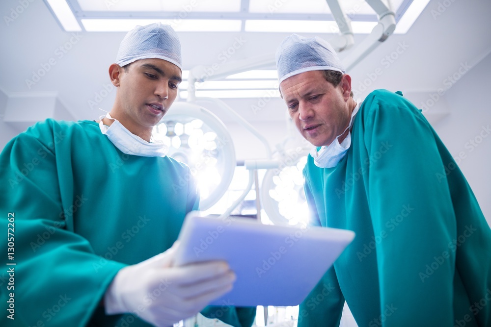 Poster surgeons using digital tablet in operation theater